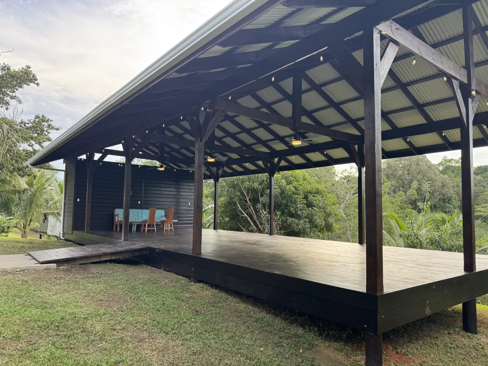 The pavilion from the lawn: a long roofed deck open to the jungle