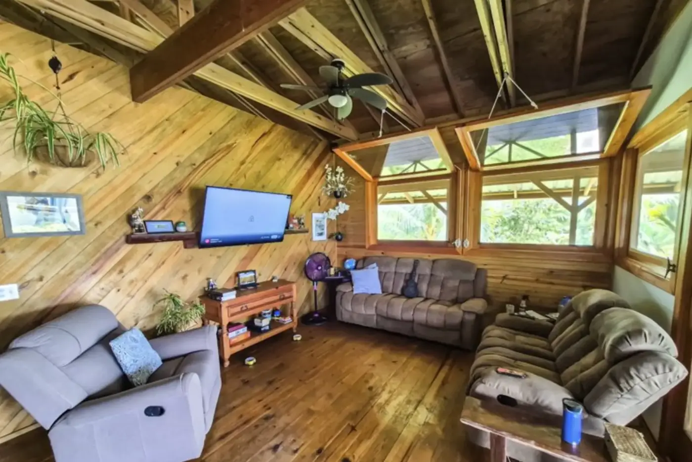 Living room with comfortable seating, wood ceiling, and water views through the windows