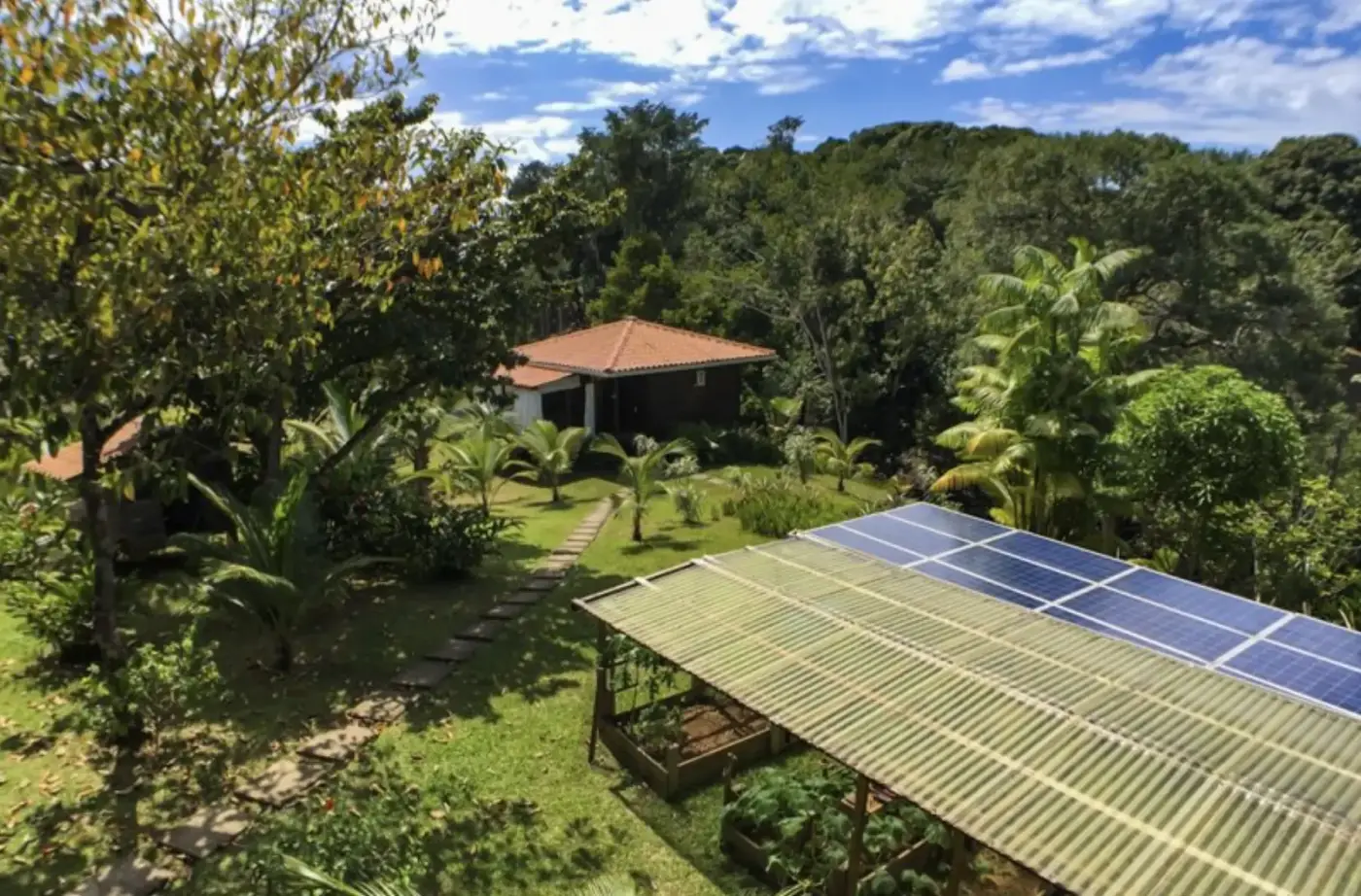 The solar array on the property, with the caretaker casita and garden beds in the background